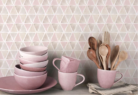 Counter with plates, bowls and cups and triangles in browns, greys and pink wallpaper