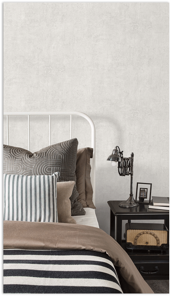 Light grey plaster texture wallpaper in a bedrrom with patterned and striped pillows   18 Mar 2015 --- Striped and patterned pillows and blanket on bed --- Image by   Hero Images Corbis