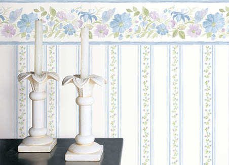 Candle on table with floral stripe wallpaper and floral bordeer in blues and purple
