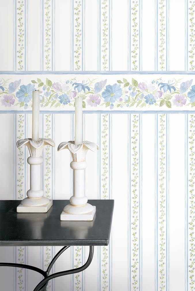 Candle on table with floral stripe wallpaper and floral bordeer in blues and purple